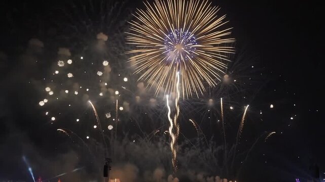 Spectacular colorful fireworks display grand finale over a cheering silhouetted crowd at night