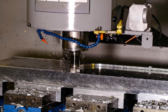 CNC machining center milling a metal part with chips