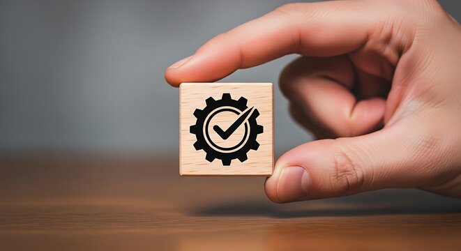 Hand holding wooden cube with gear and checkmark symbol, representing control block
