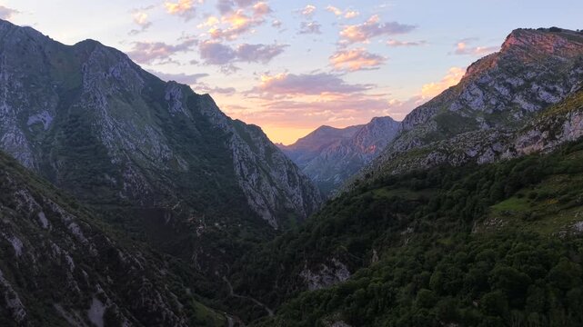 Drone video flying through the Desfiladero de los Beyos canyon in Spain at sunset. Beautiful twilight aerial of N-625 gorge road in Picos de Europa National Park.