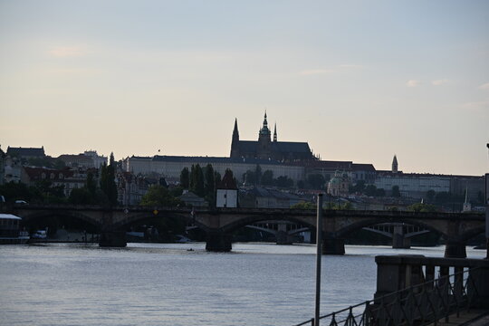 Vltava River with Stone Bridge and Prague Castle in the Background on a Sunny Day