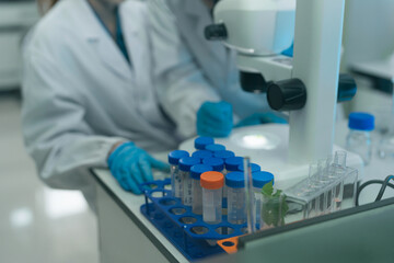 Fototapeta premium Two Asian female environmental scientists analyzing water quality samples with centrifuge and petri dish in laboratory.