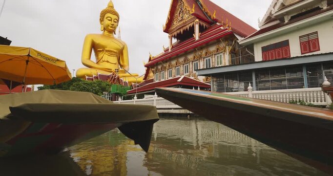 Big golden buddha statue at wat paknam phasi charoen with travel local wooden boat sightseeing travel in Bangkok Thailand
