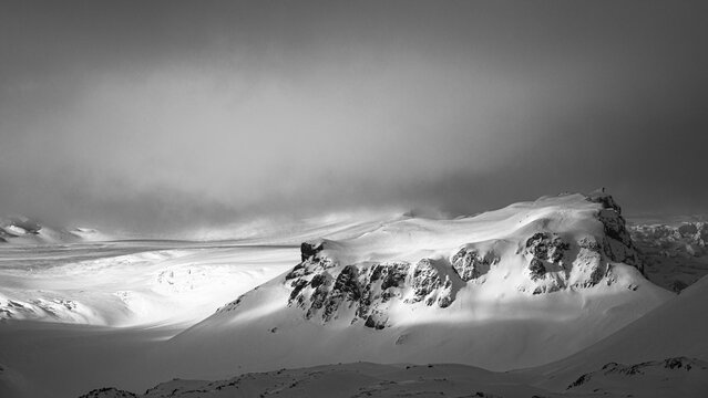 Fog, light and shadow on the snowy summit of Breidamerkurfjall, black and white photo, Sudurland, Iceland