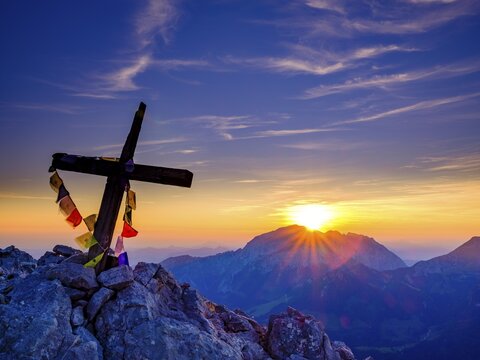 Buddhist prayer flags on the summit cross of the Kleiner Watzmann at sunrise, in the background Hoher G&ouml;ll, Berchtesgaden Alps, Berchtesgaden National Park, Sch&ouml;nau am K&ouml;nigssee, Berchtesgadener Land, Bavaria, Germany