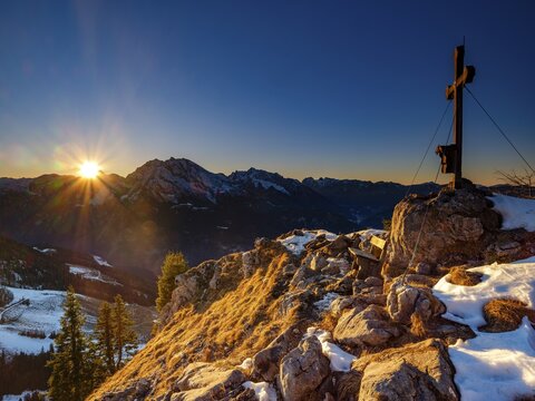 Summit cross of the board fork at sunset, in the back Watzmann, Hochkalter and Reiteralpe, Berchtesgaden Alps, Berchtesgaden National Park, Sch&ouml;nau am K&ouml;nigssee, Berchtesgadener Land, Bavaria, Germany