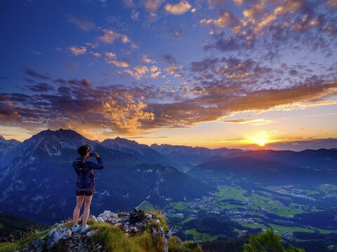 Mountaineer taking pictures of sunset with mobile phone, Watzmann, Hochkalter and Reiteralpe in the background, Berchtesgaden Alps, Berchtesgaden National Park, Sch&ouml;nau am K&ouml;nigssee, Berchtesgadener Land, Bavaria, Germany
