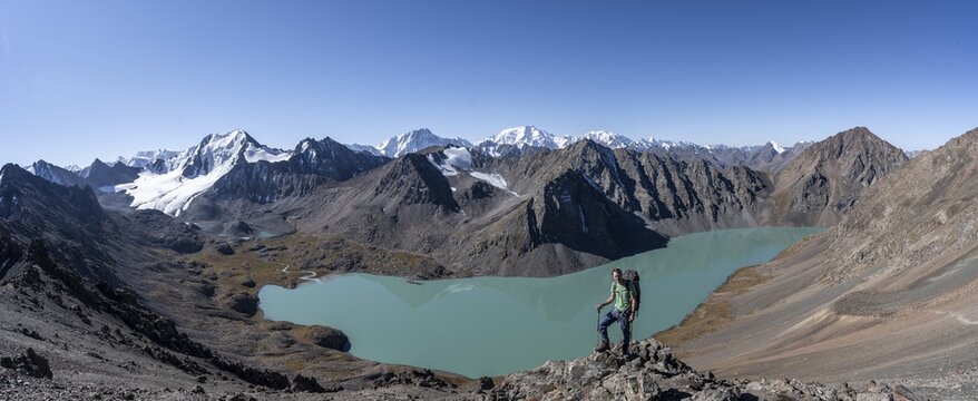 Panorama, mountaineers on the way to the Ala Kul Pass, view of mountains and glaciers and turquoise Ala Kul mountain lake, Tien Shan Mountains, Kyrgyzstan