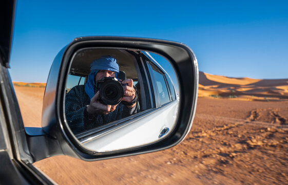 Photographer takes a "selfie" while driving through the Sahara