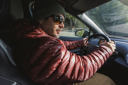 Man in red puffy jacket drives his electric car