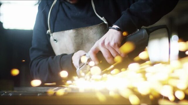 angle grinder sharpens steel. bright Sparks fly. power tool blade. spinning disc, red fire. machine cutting iron in factory. worker weld grind metal construction in industry. man blacksmith welder