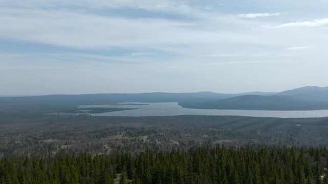 Wide landscape footage of Zyuratkul Lake surrounded by taiga forest and low mountains, filmed from a viewpoint in Zyuratkul National Park, Chelyabinsk Oblast, Russia