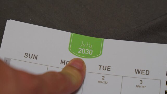 finger pointing at May 2030 planner page close up for scheduling and monthly planning concept