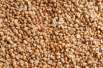 Fototapeta premium Top view of roasted peeled peanuts background texture.