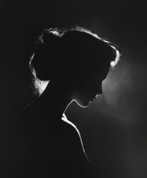 Dramatic backlit silhouette portrait of woman in profile