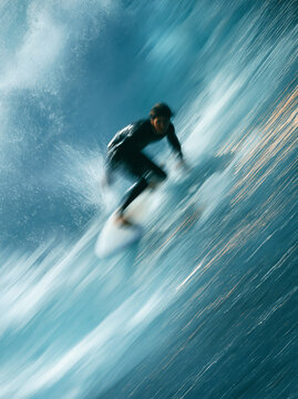 Surfer riding a sunny summer wave with fresh ocean spray