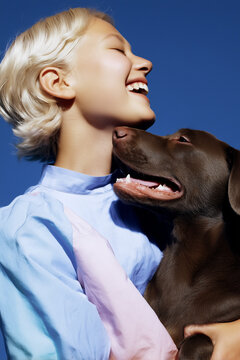 Joyful woman cuddling brown dog against blue sky