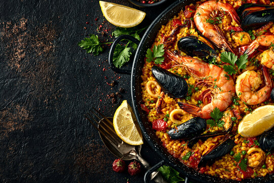 Seafood paella in pan with shrimp, mussel and lemon