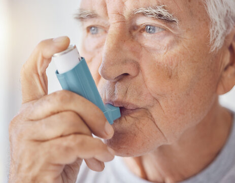 An elderly male patient managing a chronic respiratory condition using a prescribed metered-dose inhaler during a medical treatment session