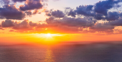 Fototapeta premium beautiful sunrise or sunset seascape with amazing calm sea water with waves and colorful amazing cloudy morning sky on background