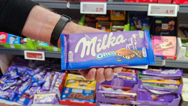 Hand holding milka oreo chocolate bar in store
