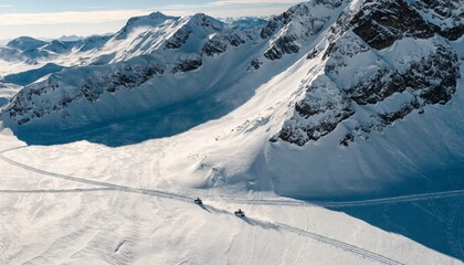 Aerial view of snow mobiles traveling across a snowy arctic tundra in the high mountains on a cold winters day.  © pinan