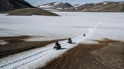 Aerial view of snow mobiles traveling across a snowy arctic tundra in the high mountains on a cold winters day.  © pinan