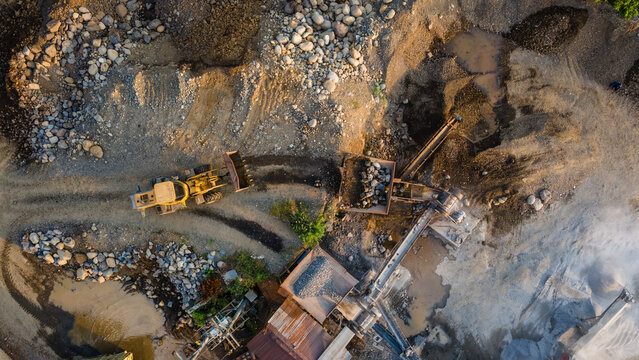 Aerial View of Wheel Loader and Rock Crusher Working in Industrial Quarry Mining Site
