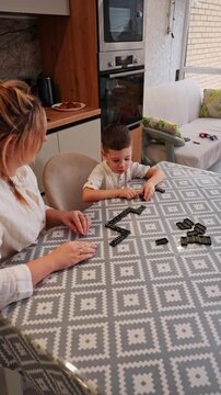 Mother and son playing dominoes at home together