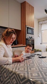 Mother and son play dominoes at home