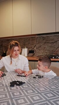 Mother and son playing dominoes at home