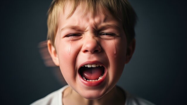 Little boy crying loudly with mouth open.