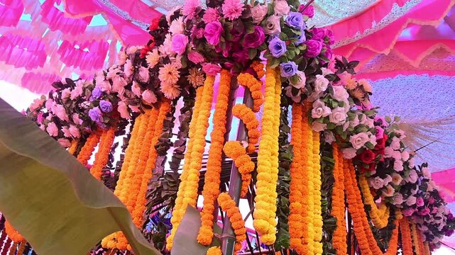 Traditional Indian Wedding Stage Decor with Flowers and Lights, Colorful floral decorations and marigold garlands arranged for an Indian wedding ceremony. The decorative wedding backdrop