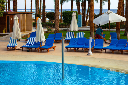 Main swimming pool in the foreground at Brayka Bay Resort, Marsa Alam, Egypt, with sun loungers and parasols beside the pool area