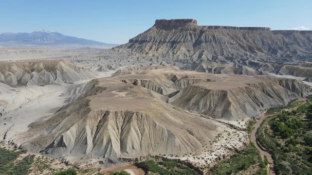 Detailed 4K drone shot tracking to the right across unique eroded clay ridges and geological formations near Factory Butte, Utah. Linear horizontal movement at 60fps, perfect for slow-mo or reverse.