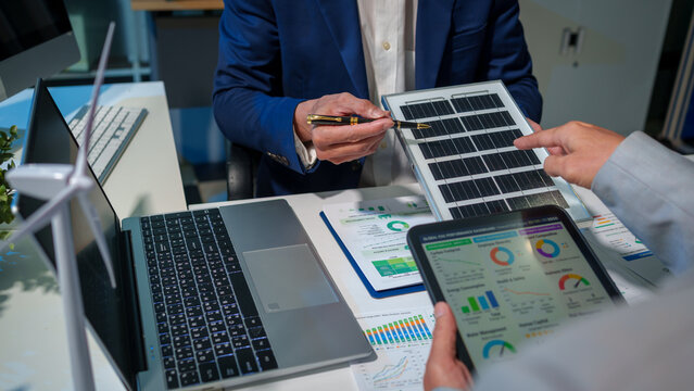 Corporate professionals in a boardroom analyze ESG performance dashboards. sustainable ecological strategies, discussing investments and environmental impact for future global corporate growth.