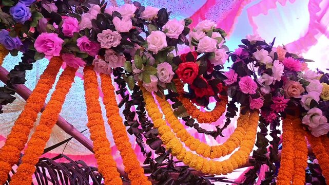 Luxury Wedding Venue Decoration with Colorful Flower Arrangements, The decorative wedding backdrop features flowers, lights, floral arches, and festive stage elements used during marriage celebrations