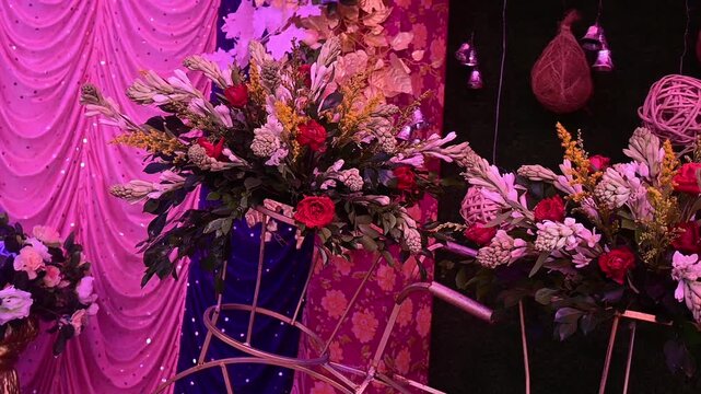 Luxury Wedding Venue Decoration with Colorful Flower Arrangements, The decorative wedding backdrop features flowers, lights, floral arches, and festive stage elements used during marriage celebrations