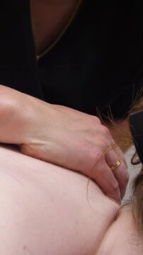 Spa. A massage therapist is working with a young woman - Vertical video