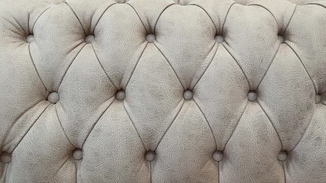 Close-up of beige textured tufted couch upholstery background showing detailed fabric pattern
