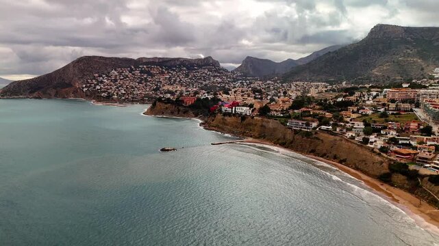 Aerial drone approach to La Muralla Roja and cliffs, Calpe, Spain