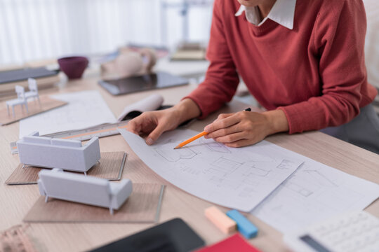 interior designer architect creating furniture design blueprint sketch planning layout with scale model at studio office workspace creative professional