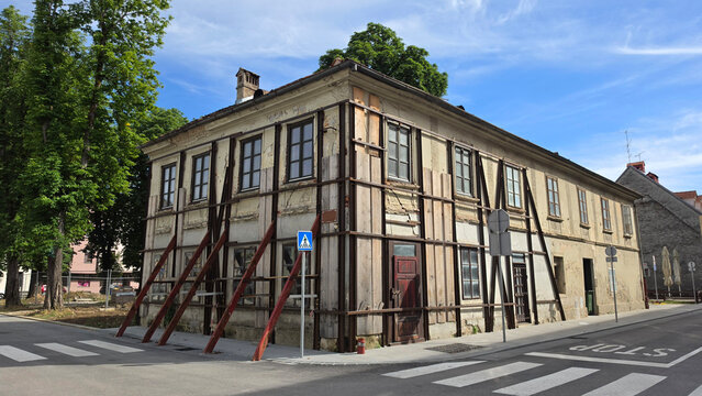 Historic multi-story building facade reinforced with external steel columns and wooden structural bracing