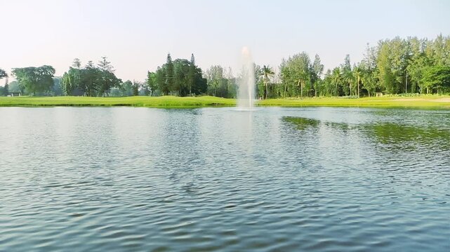 Serene Lake Fountain Green Park Landscape Under Clear Blue Sky. Beautiful freshwater lake with a fountain surrounded by green trees and grass under a clear blue sky
Tangerang, Banten, Indonesia. 