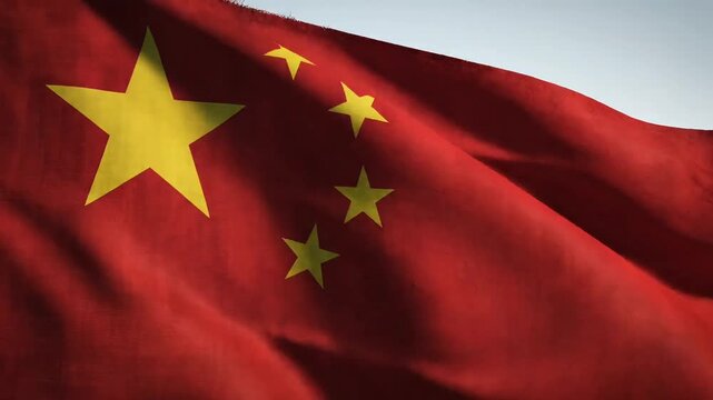 Waving Chinese flag against a clear sky, symbolizing national pride and patriotism.