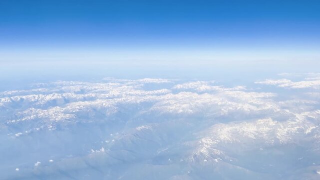 Aerial view of French Alps summits piercing dramatic cloud layers
