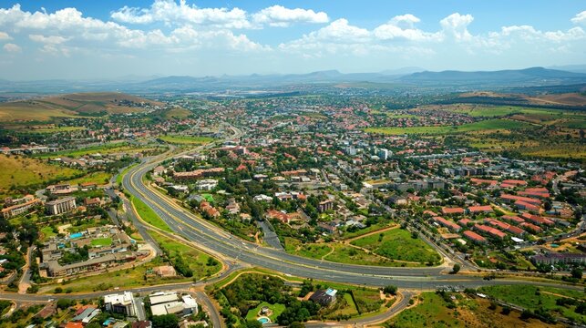 An aerial view of the urban sprawl of South Africa&acirc;&euro;&trade;s cities, showing roads, buildings, and green spaces.