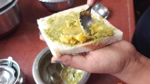 Spreading Mashed Potato Stuffing on Bread Slice for Sandwich Preparation