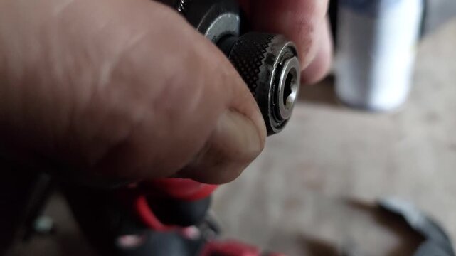 Close-up of a hand inserting or releasing a quick release chuck mechanism on a power tool