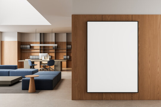 Large empty poster mockup on wooden wall in modern office interior with seating area and workspace in contemporary design. 3D Rendering